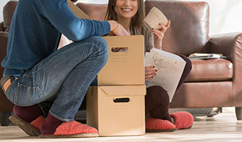 Casal empacotando os pertences para fazer mudança